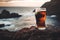 A glass of fresh stout beer on rocky beach on sunny summer evening. Beer on a background of Irish nature. Drinking alcoholic