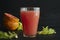 A glass of freshly squeezed grapefruit juice with grapefruit slices close-up on a black background