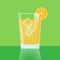 a glass of freshly squeezed orange juice with an orange slice and bubbles in a transparent glass on a green background.
