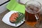 A glass of frothy beer and salmon steak with rosemary.