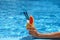 Glass of fruity cocktail in a woman s hand on pool water background