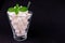 A glass full of sugar on a black background. The concept of harmful sweet carbonated drinks.