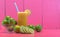 Glass of Galician lemon juice Citrus auranti and halved fruits on pink background