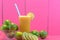 Glass of Galician lemon juice Citrus auranti and halved fruits on pink background
