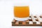 Glass glasses with orange juice on a wooden stand. A soft drink in a glass on a white background