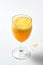 Glass goblet with bubbling orange liquid on a white background.