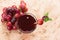 Glass of grape juice and branches of grapes on a light brown background. View from above.