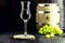 Glass of Grappa on wooden background with old oak barrel, grape-based drink, distilled. Selective focus