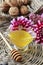 Glass gravy boat with honey, dahlia flowers in the background