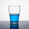 Glass half full of blue liquid