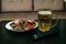 Glass half-liter mug filled with beer, dried smoked fish and TV remote control on the table