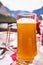 A glass of Hallstatt local beer on the table at a romantic restaurant beside the Hallstattersee Lake in High Alps Mountains, a
