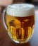 Glass with handle full of light beer with foam-