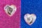 Glass hearts symbolizing a man and a woman lie on a shiny blue and red background. A picture of gender differences. Blank for