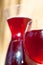 Glass of homemade red wine with carafe on stone wall background