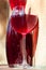 Glass of homemade red wine with carafe on stone wall background