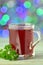 Glass of hot borsch soup on bokeh background