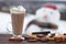 Glass of hot chocolate or cappuccino with cream and chunks of dark chocolate