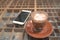 Glass of hot mocha coffee on glass floor with smart mobile phone.