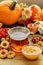 Glass of hot steaming tea, bowl of peach jam and autumn plants