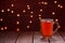 Glass of hot tea on wooden table christmass new year lights background