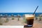 Glass with ice coffee fredo espresso or frappe on the corner of the table with beach on background