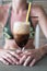 Glass of ice coffee with milk with two straws over womans bikini neckline background