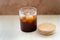 a glass of iced americano. glass of cold coffee with steam. new generation coffee shops and cold brew. on white wooden line