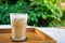 Glass iced coffee on wood table green nature background,Iced latte coffee