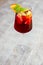 Glass of iced sangria with strawberry, orange, apple and lemon on the table