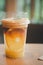 Glass of iced sparkling americano coffee with pieces of fresh orange