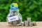 glass jar bottle labeled as house with full of coins and miniature house and stack of coins as home, property or mortgage