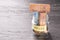 Glass jar with coins and euro notes with the word HOUSE on a black wooden table