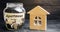 A glass jar with coins and a wooden house and the inscription `Apartment`. The accumulation of money to buy an apartment. Rent an