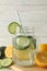 Glass jar of cucumber water, slices and lemons on background, close up