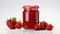 a glass jar filled with vibrant strawberry jam on a clean, white wooden surface to emphasize the freshness and