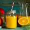 glass jar of fresh orange juice with fresh fruits on wooden table