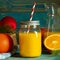 glass jar of fresh orange juice with fresh fruits on wooden table