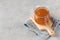 Glass jar with fruity orange jam on a grey background. Fruit preservation.