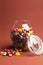 Glass Jar full of bright colorful lollies and candy with open lid - vertical with copy space