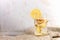 Glass jar with ginger water on burlap on wooden table on light background.