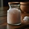 Glass jar with Himalayan salt. Blurred brown background. A pile of coarse sea salt on a wooden table. AI generated.