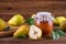 Glass jar of homemade pear jam with fresh fruits and ingredients