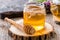 Glass jar of honey with honey dipper on wooden slice close-up