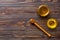 Glass jar of honey with wooden drizzler on colored background. Honey pot and dipper high above. Top view copy space