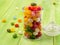 glass jar with lid filled with colorful candies on a wooden green background