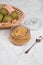 Glass jar with mashed pears and fresh pears in a wicker plate on a light background .