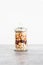 Glass jar of mixed nuts including almonds cashews and pistachios, natural healthy pantry ingredients