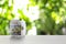 Glass jar with money and label HEALTH on table against blurred background