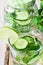 Glass and jar mug with infused detox cucumber water with lime and fresh mint, close up, cleansing